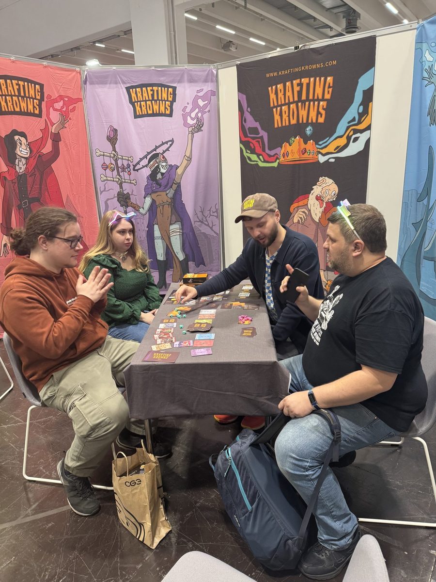 Players around a Krafting Krowns table